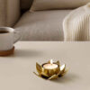 Porte-bougie en acier brillant avec design de lotus en doré.