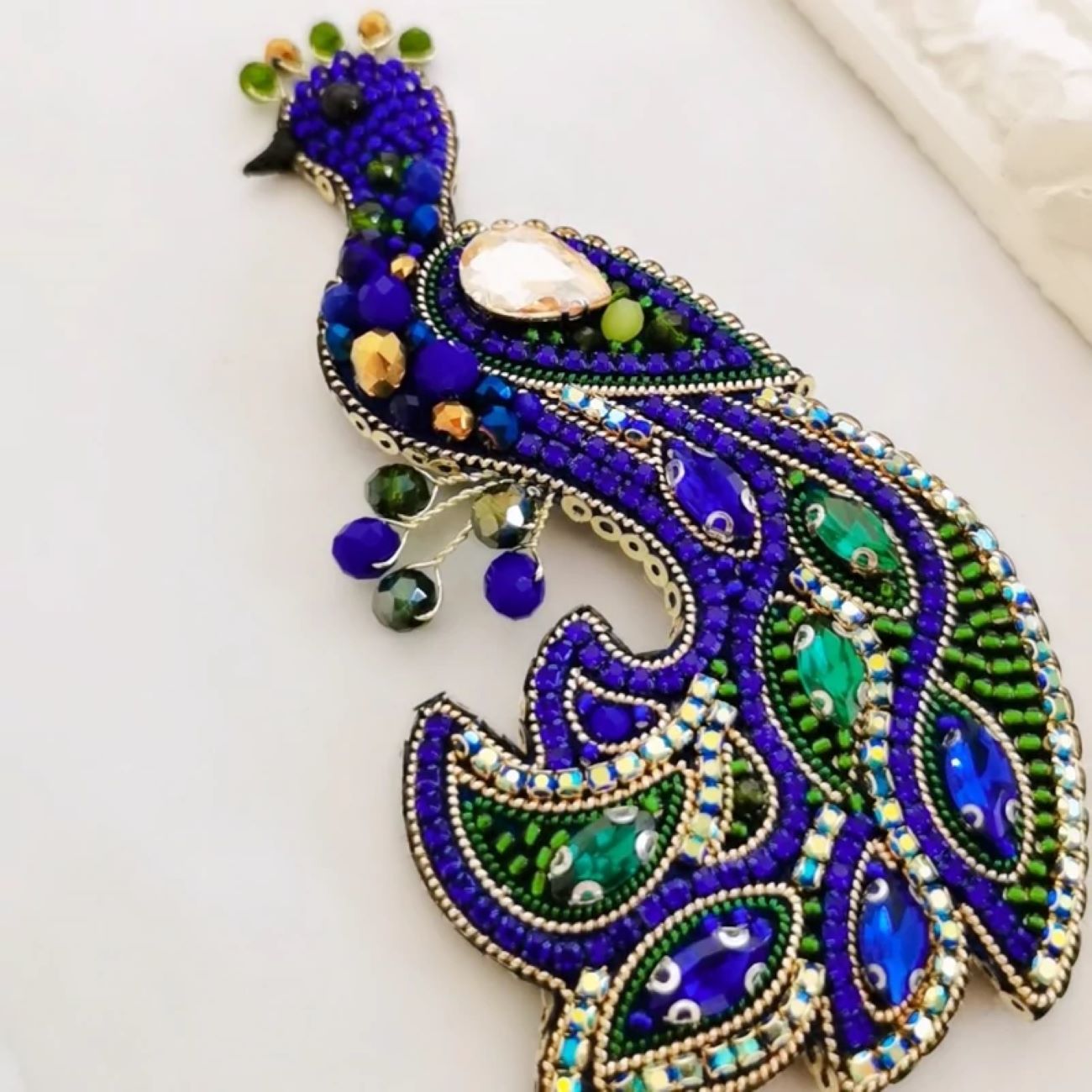 Broche paon perlée – une touche de beauté sauvage