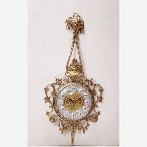 Charmante horloge murale en laiton avec décor floral et détail suspendu